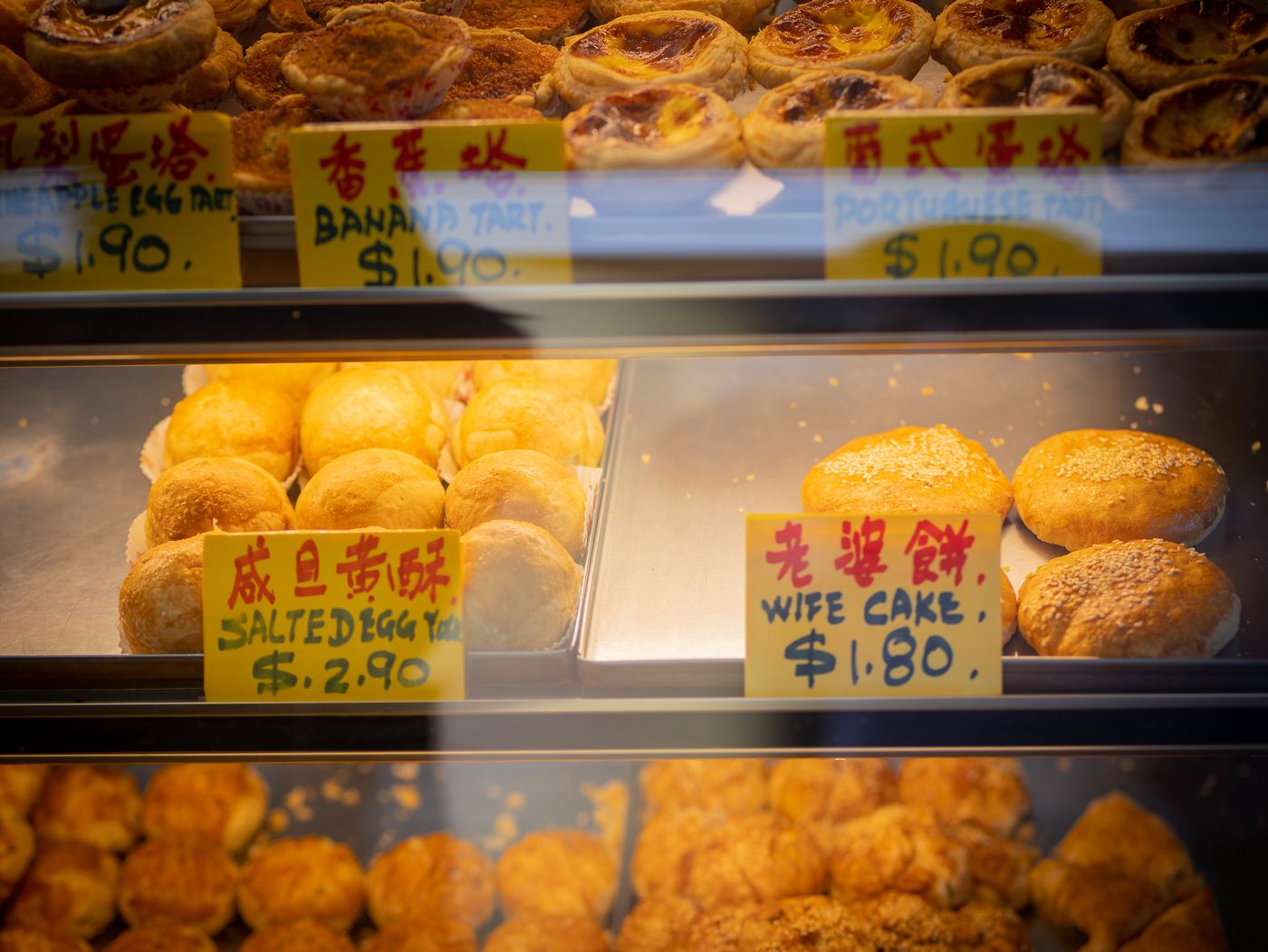 Vitrine einer Bäckerei mit Egg Tarts und Wife Cakes
